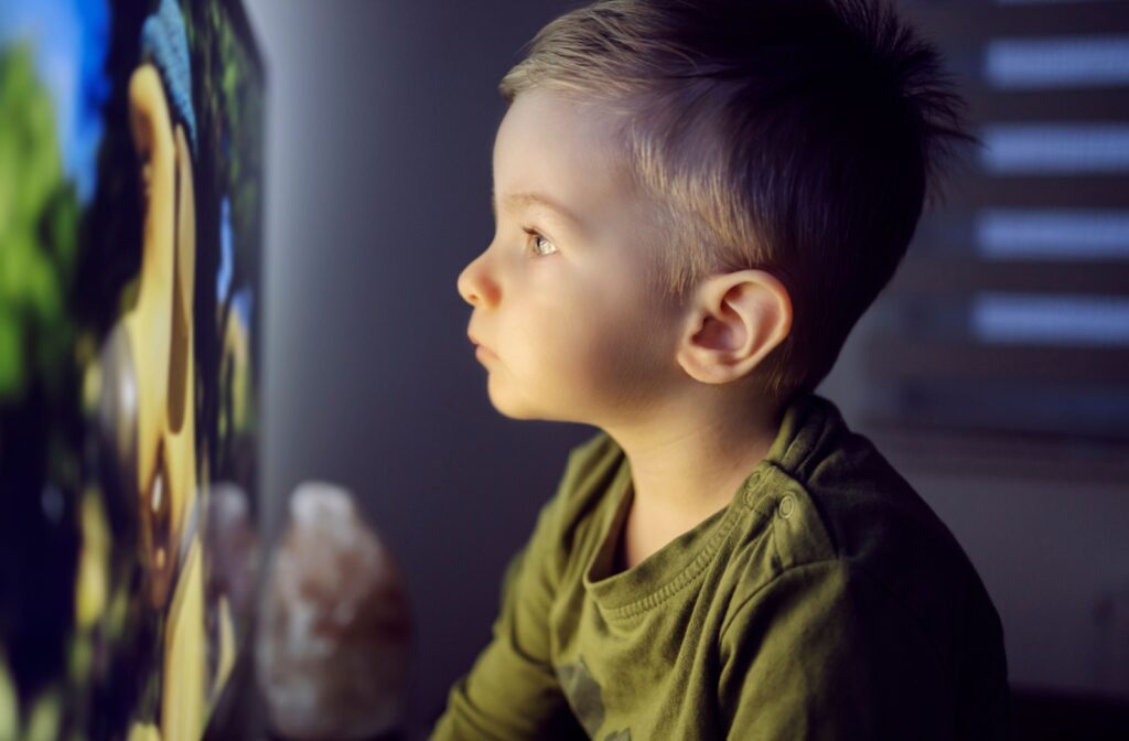 Child watching TV up close, a behavior linked to worsening myopia.