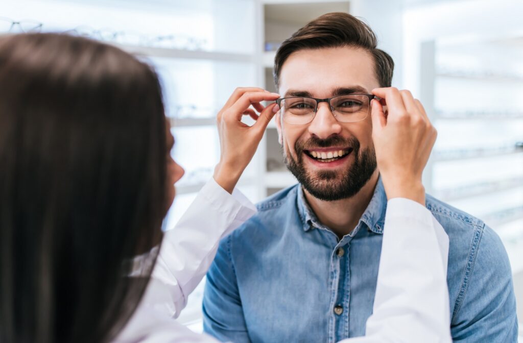 An optometrist assists their patient while they try on a new pair of glasses.
